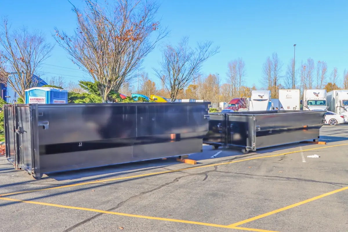 Professional dumpster rental service with roll-off container on residential driveway in Ozark